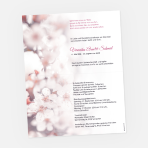 Eine Trauerkarte mit zarten, verschwommenen Kirschblüten und deutschem Text in Schwarz und Rosa, die Veronika Arnold-Schmid ankündigt.